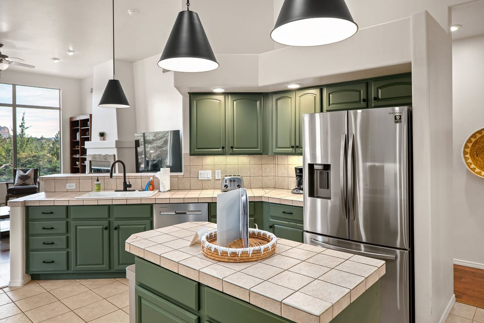 Unleash your inner chef in this dream open-concept kitchen with a large island, where tiled countertops and well-stocked appliances set the stage for culinary creativity.