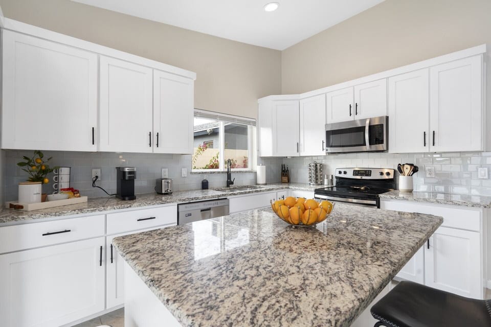 Island in the kitchen includes additional bar seating for 2