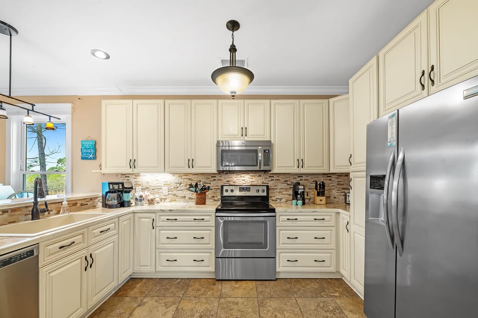 Open kitchen contains full sized appliances, coffee maker, and a pantry.