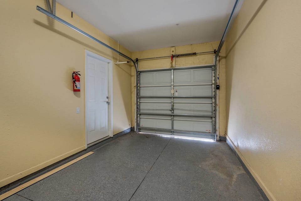 Laundry room with washer and dryer located in garage