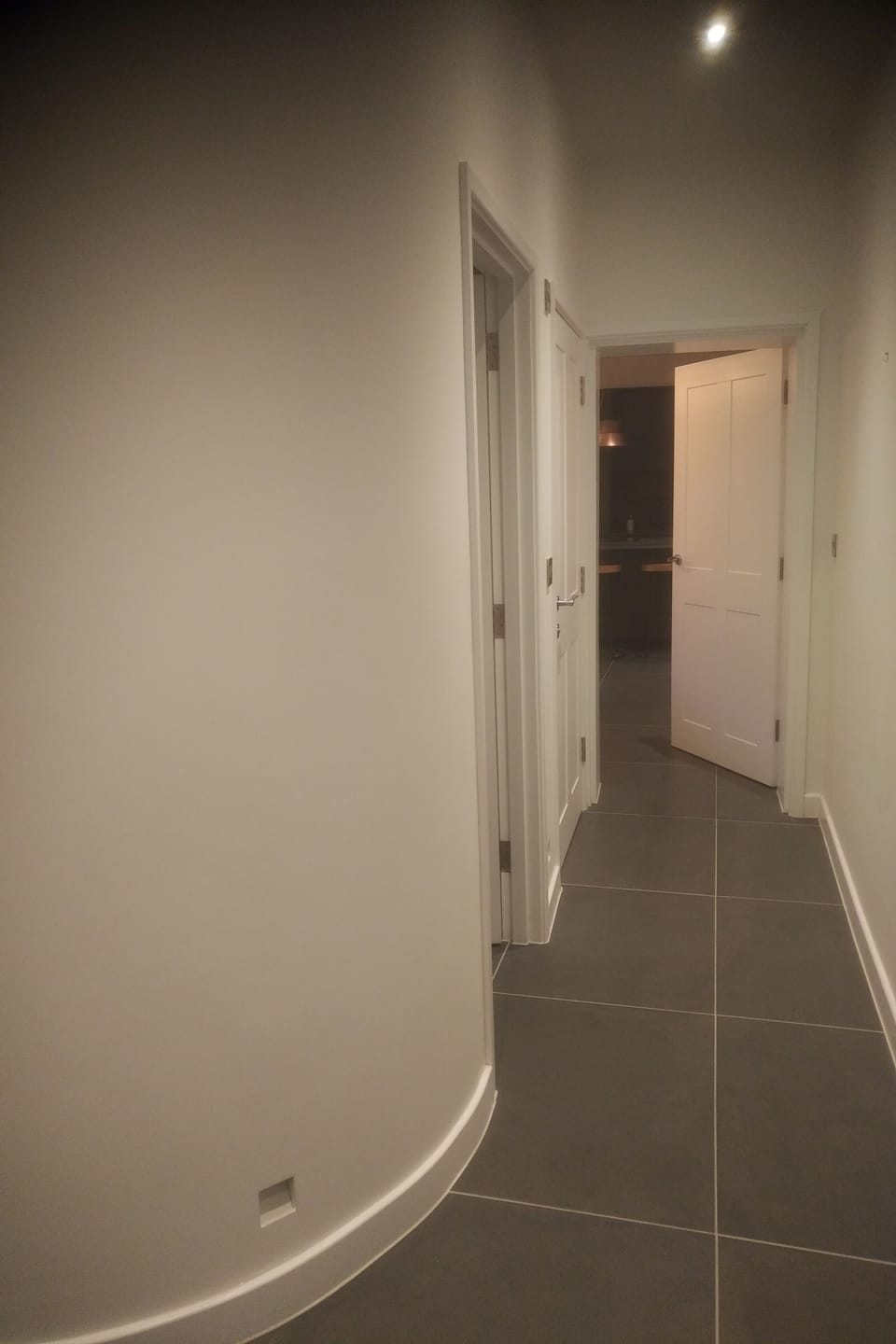 Hallway leading to utility room, cloakroom, kitchen and courtyard