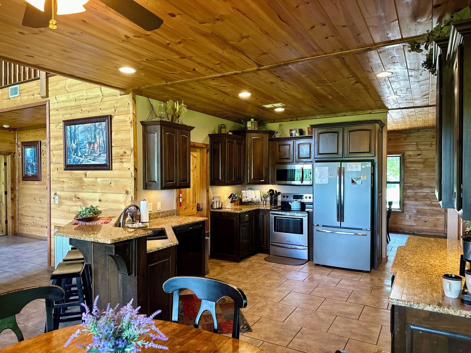Well-stocked kitchen, breakfast bar, and dining table.