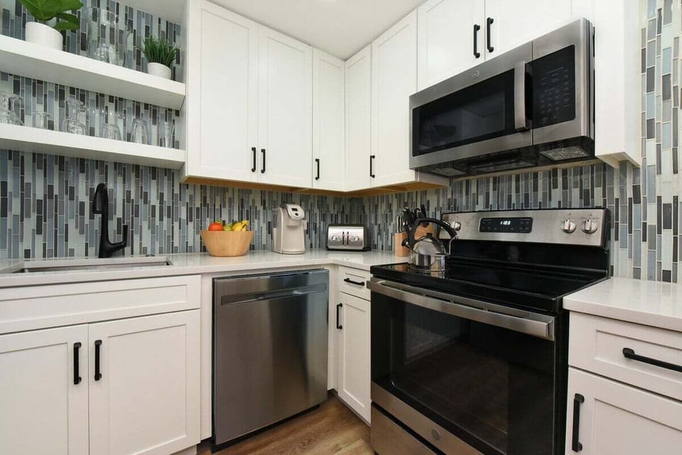 Functional kitchen with stainless steel appliances and white cabinets