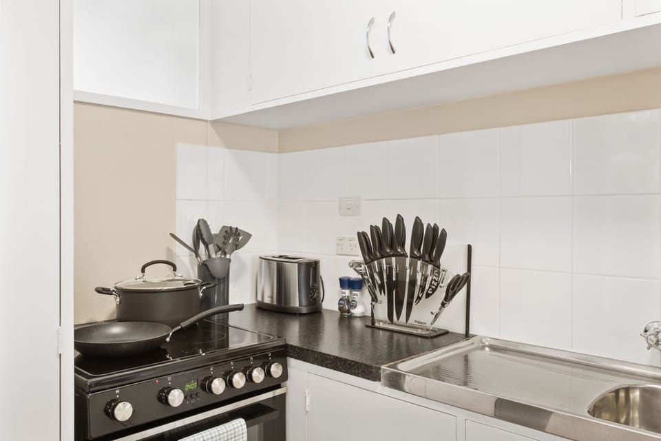 Kitchen fully stocked with plates, bowls, glasses, and cooking pots/pans.