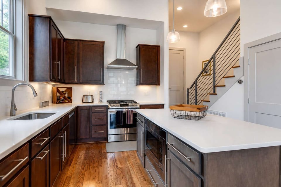 Modern kitchen featuring wooden cabinetry, stainless appliances, and a central island.
