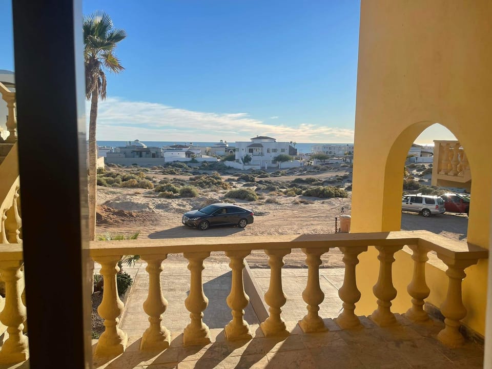 Very from 1st floor entry. Shows vacant lot, 1 row of houses, then the beach. 
