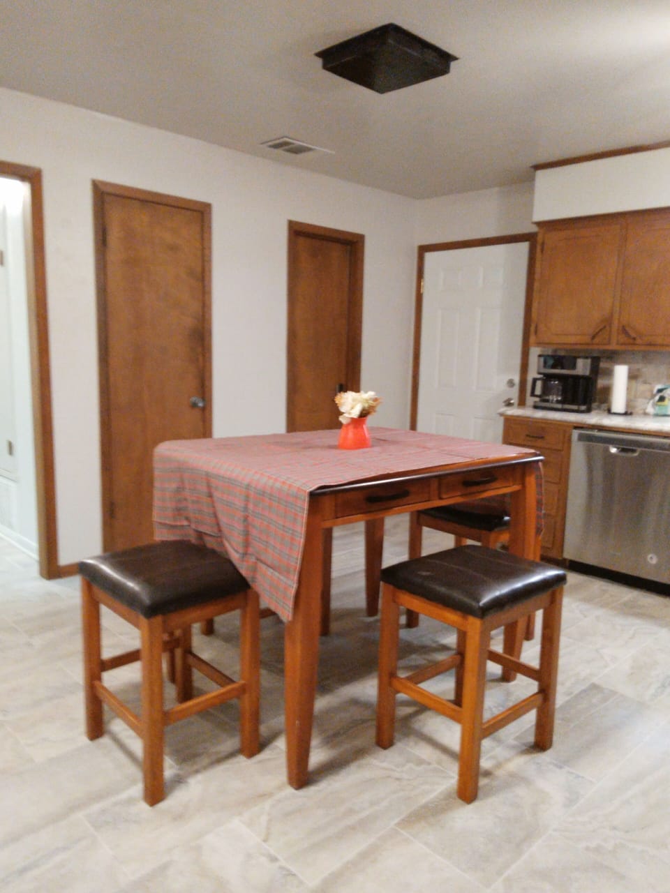 Kitchen w table and 4 chairs, fridge, microwave, stove, dishwasher, and dishes.