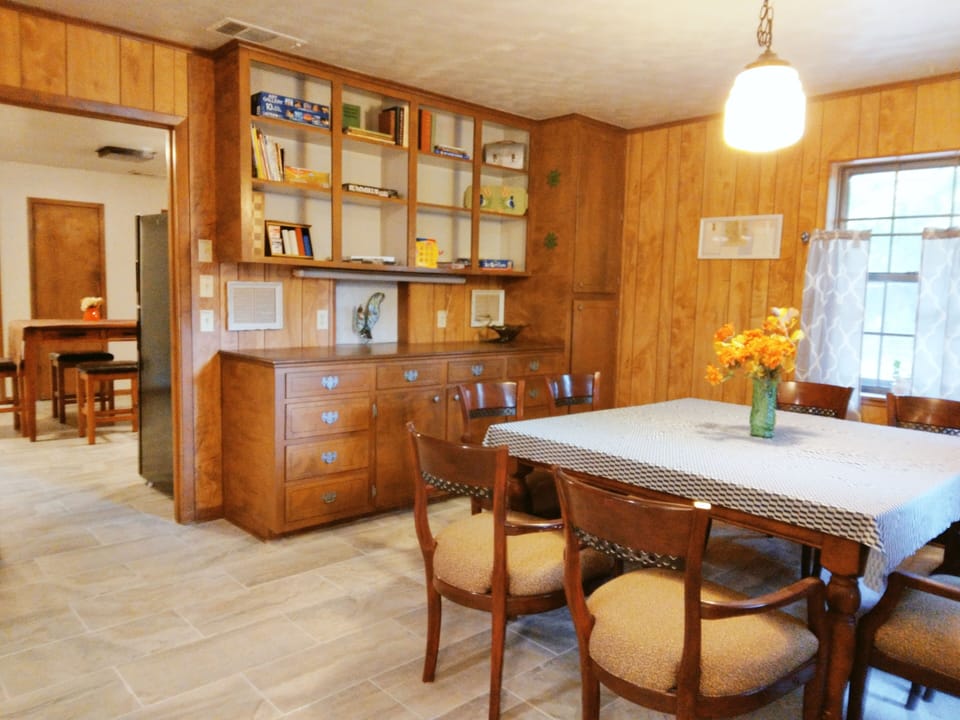 Dining room with table and 8 chairs. Kitchen has another table with 4 chairs.