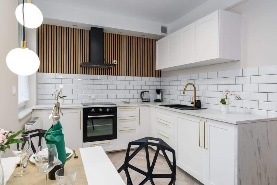 A compact yet functional kitchen with white cabinetry and modern appliances.
