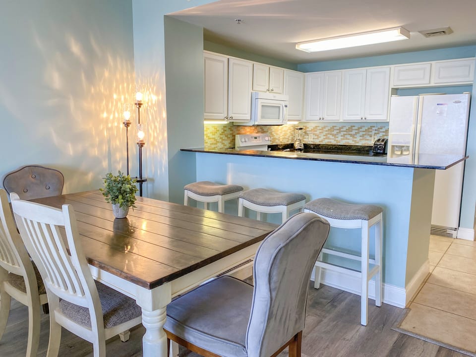 Spacious dining area with seating for 6 at the table and 3 at the bar
