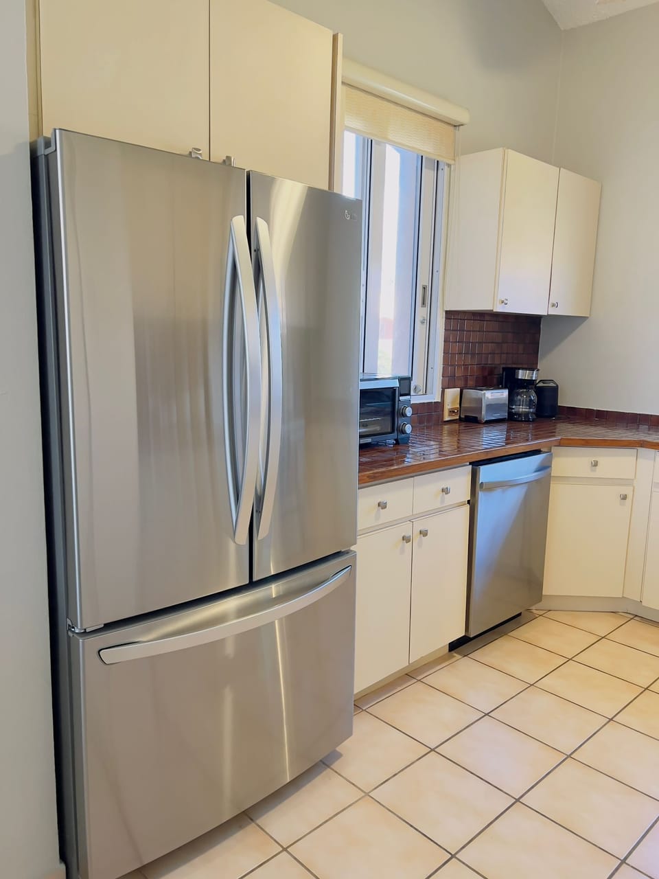 The kitchen is equipped with a large refrigerator and dishwasher