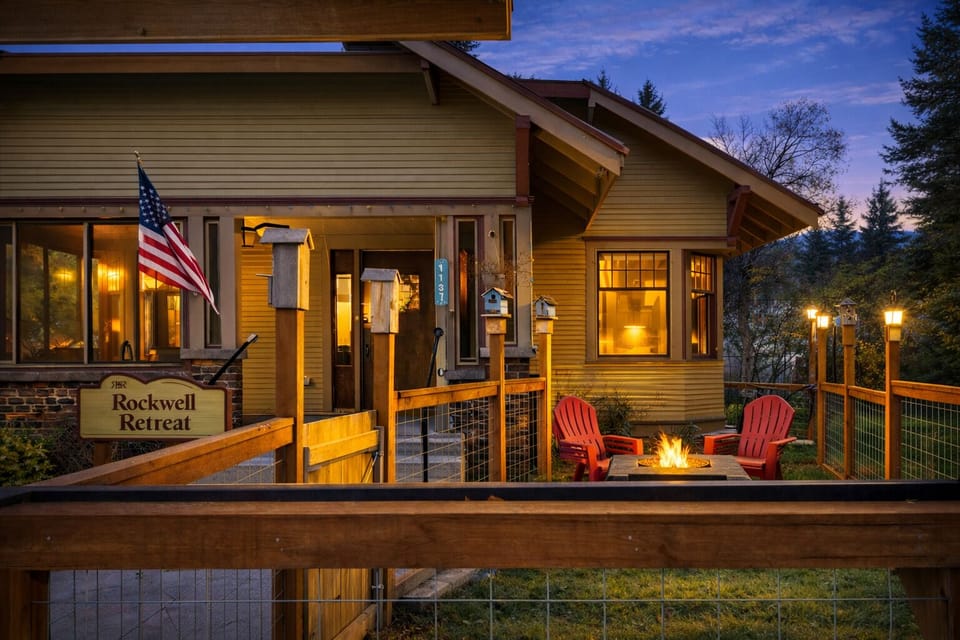 Rockwell Retreat's cozy evening ambiance features warm lighting and red Adirondack chairs around the fire pit.