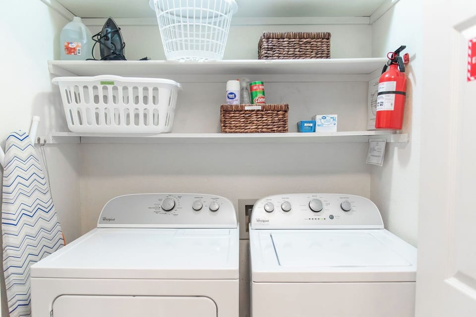 Small closet off of the kitchen has washer/dryer, iron, and pool towels.