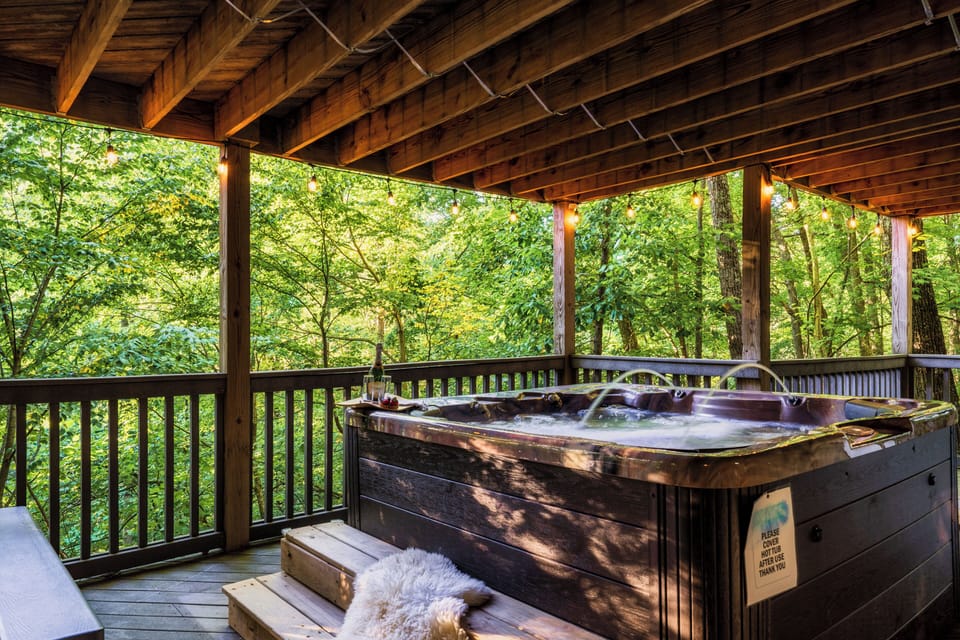 Large private 7-person hot tub on lower deck looking out over the forest.