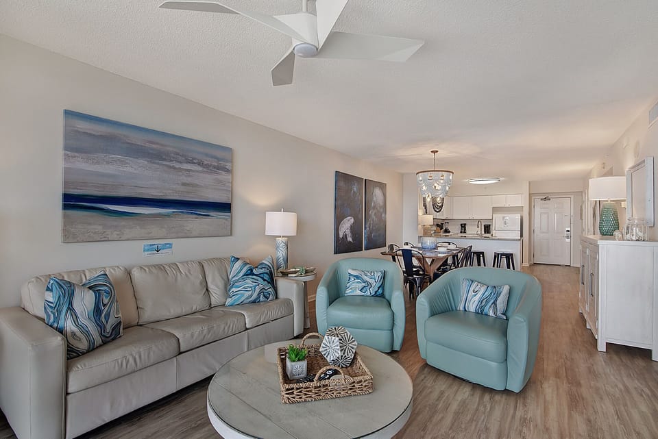 Sink into plush seating with ocean-inspired touches in your bright, airy living space featuring modern coastal decor and open-plan comfort.