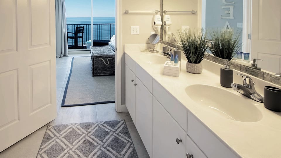 Master bath with double sink vanity, hair dryer and tub/shower combo.