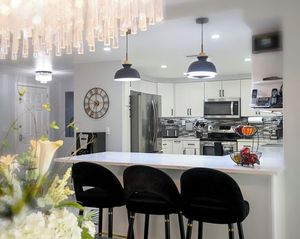Your sleek kitchen awaits with modern appliances, stylish pendant lighting, and a breakfast bar perfect for morning coffee or evening conversations.