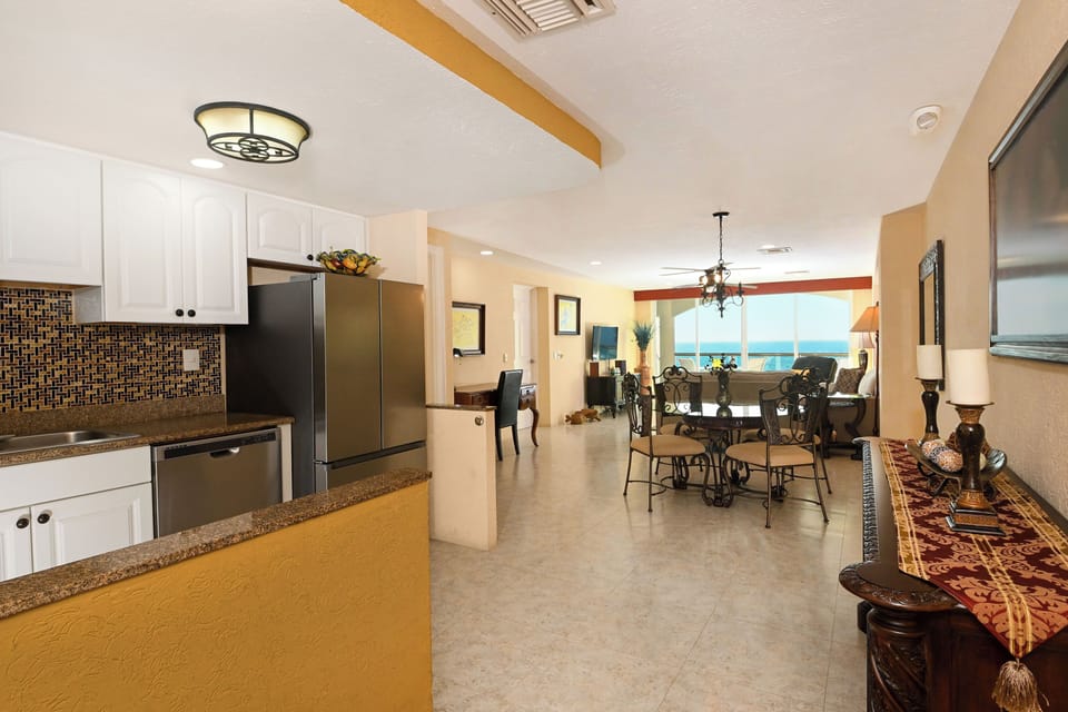 Step into your elegant open-plan retreat with modern kitchen, granite counters, and stunning sea views through floor-to-ceiling windows.