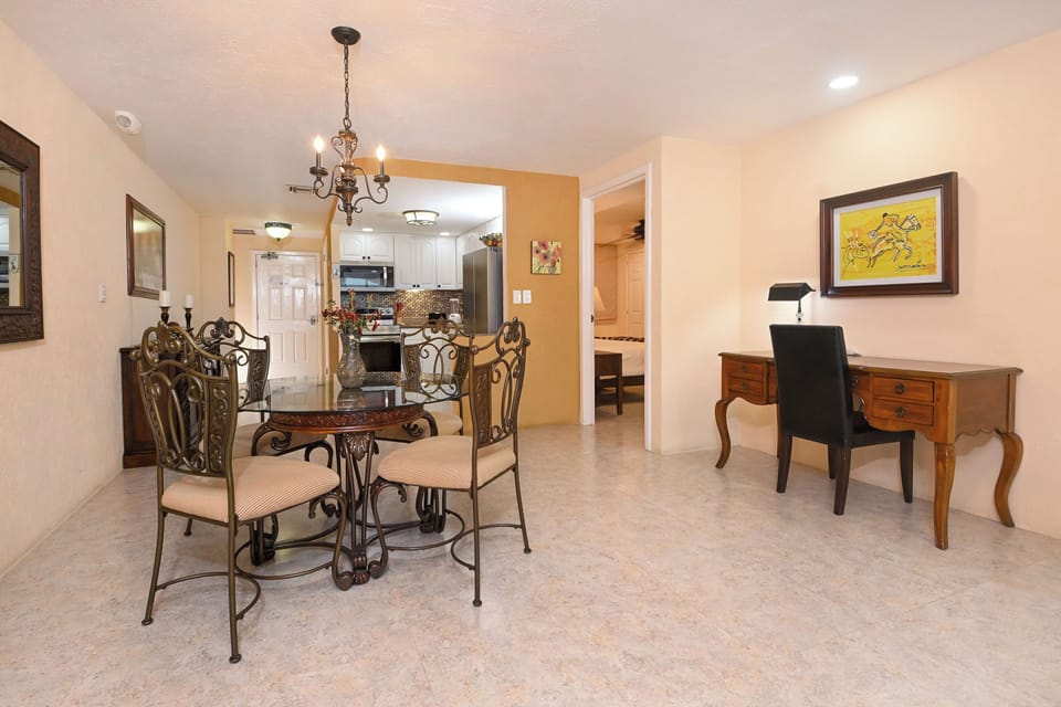 Your elegant dining space flows seamlessly into the kitchen, with ornate iron chairs and warm lighting creating perfect ambiance for memorable meals together.