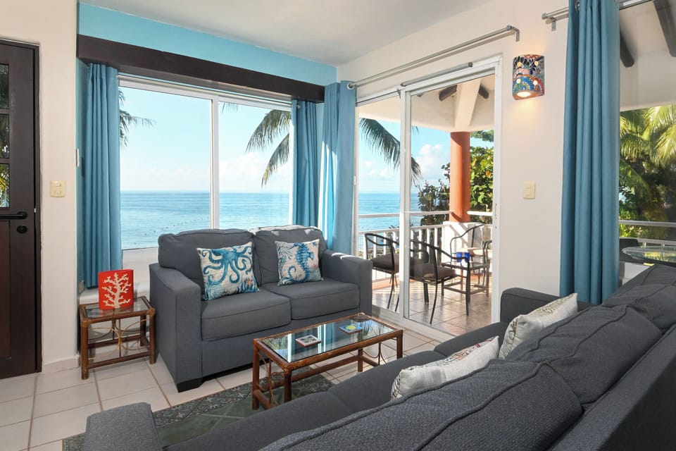 Relax in your oceanfront living room with stunning sea views, comfortable seating, and direct balcony access to paradise.