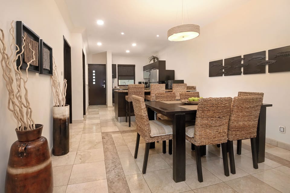 Your elegant dining space features natural wicker seating and warm earth tones, perfect for gathering over memorable meals in comfort.