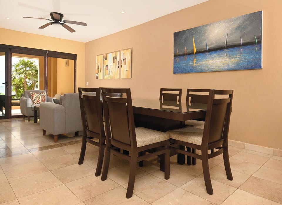 Gather with loved ones in this bright, inviting dining space with seating for six, tropical garden views, and a cozy adjoining living area perfect for memorable meals together.