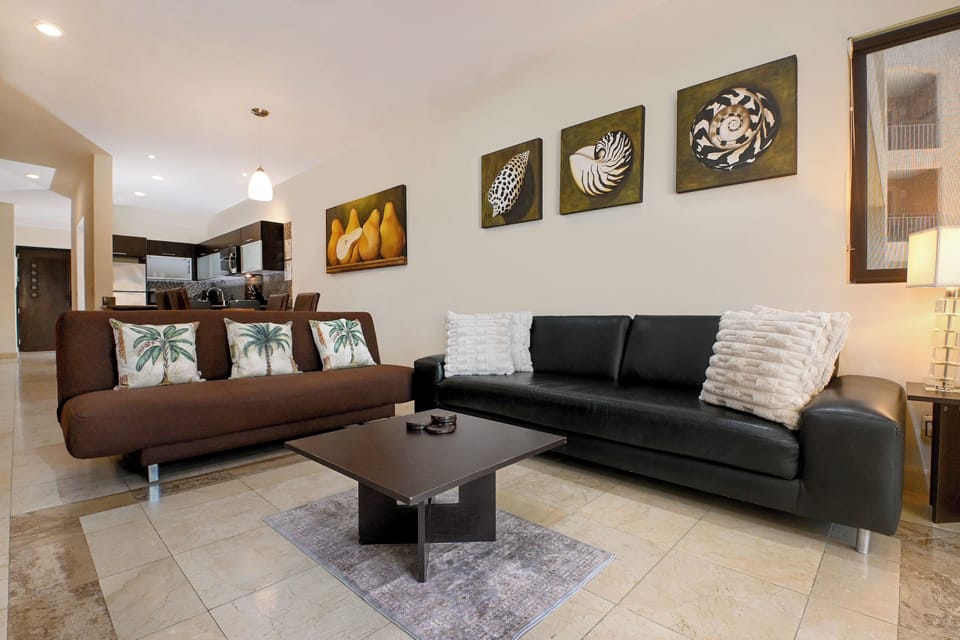 Settle into this inviting living room where coastal charm meets comfort. Sink into plush sofas, gather around the sleek coffee table, and feel instantly at home in your tropical retreat.