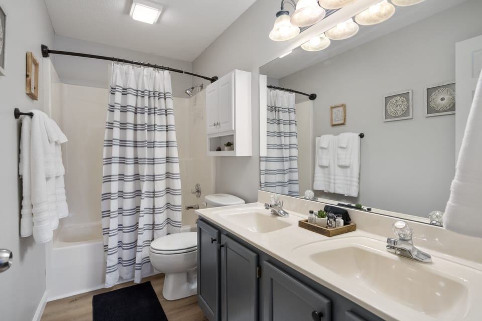 The primary bathroom has dual vanities and a shower/tub combo. 
