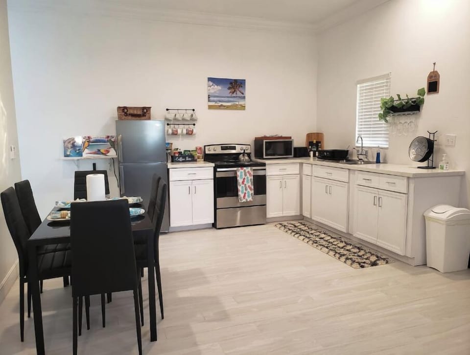 Kitchen area with fridge, stove, coffee bar, microwave, toaster & wine rack