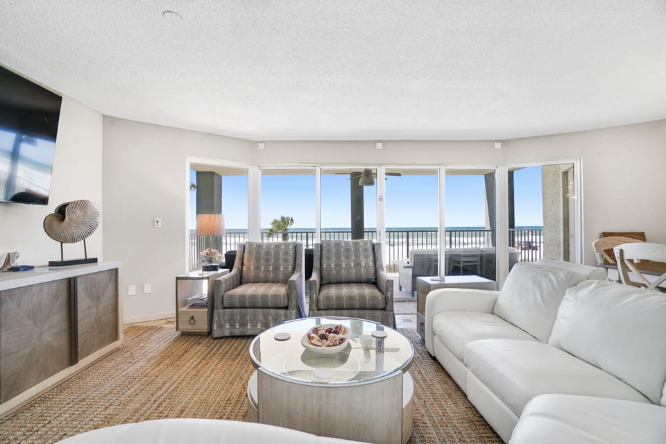 Your spacious living room opens to stunning ocean views through floor-to-ceiling windows, creating the perfect seaside retreat.