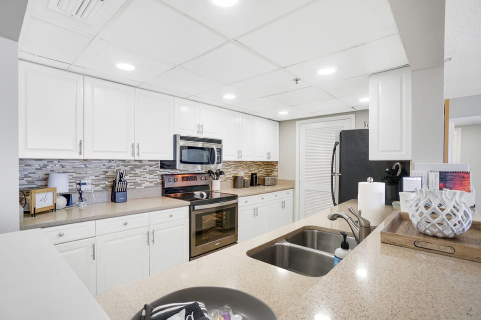 Cook your favorite meals in this bright, fully-equipped kitchen with modern appliances and stylish tile backsplash.