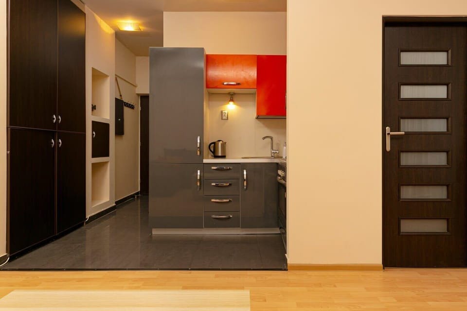 Kitchenette with electric kettle and refrigerator. 