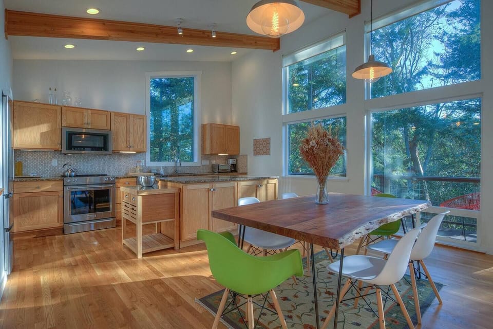 Beautiful open kitchen and dining area with windows to the outside.