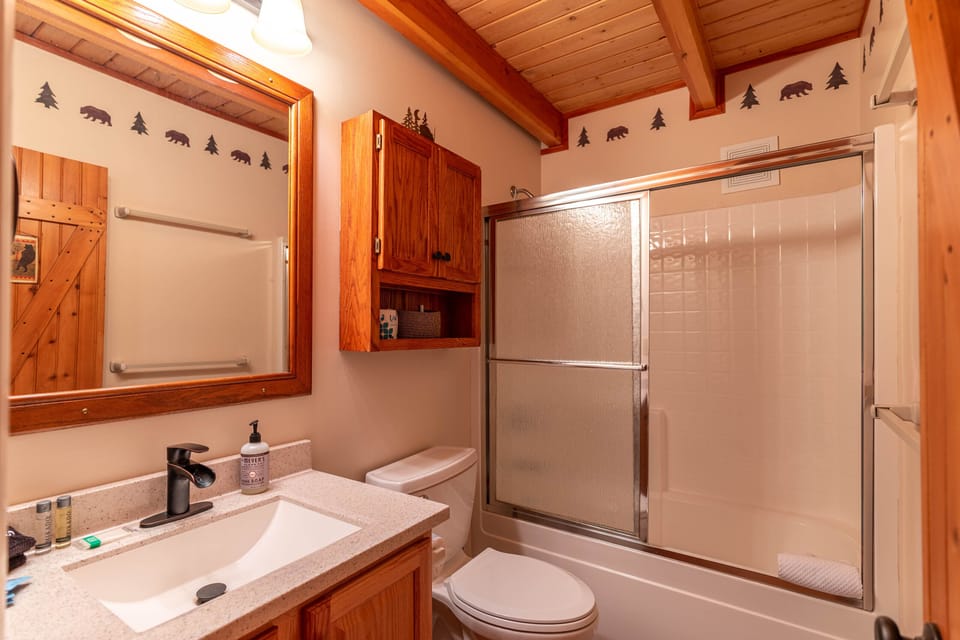 Rustic cabin charm meets everyday comfort, with bear and pine accent borders under warm wood-beamed ceilings.