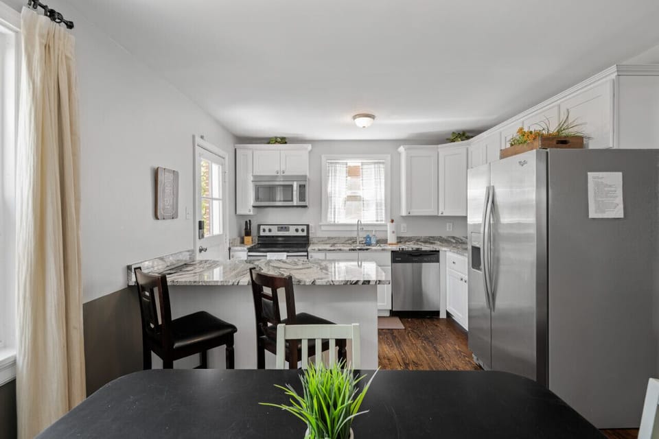 Dine in style! A spacious table for 4 plus additional seating at the kitchen bar for quick bites. Large windows flood the space with light, making it the perfect spot to gather.