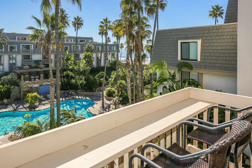 Lovely view from the downstairs balcony including the pool and a peek of the ocean waves.