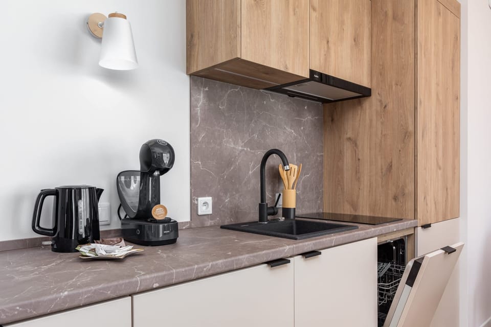 Close-up of the kitchenette countertop where the coffee machine and electric kettle are located. The overall design is stylish and functional.