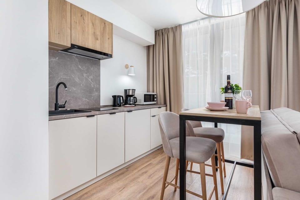 A kitchen corner with sleek cabinetry, a coffee machine, and ample countertop space.
