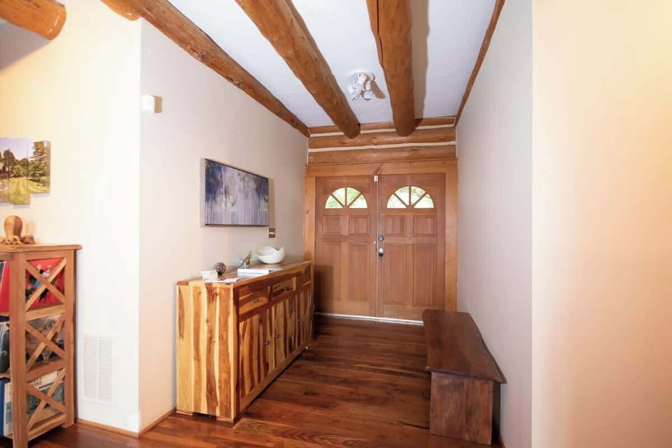 Entry foyer with buffet that contains formal dinnerware and extra serveware.