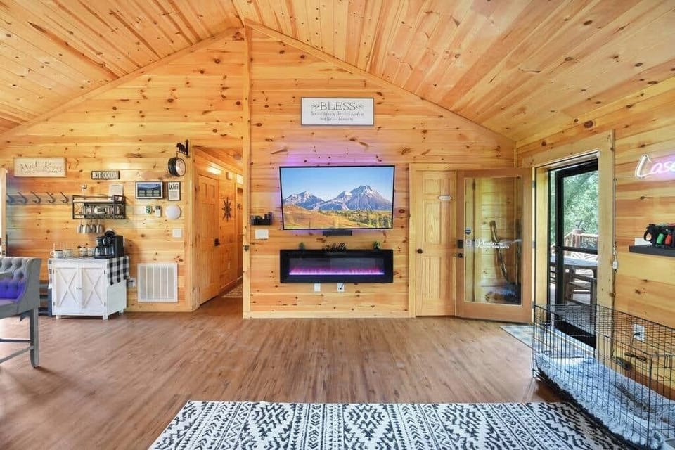 Cozy rustic living area with a mounted TV and electric fireplace.