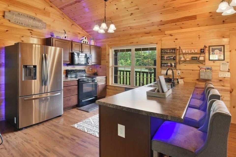 Modern kitchen with stainless steel appliances and a large island seating area.