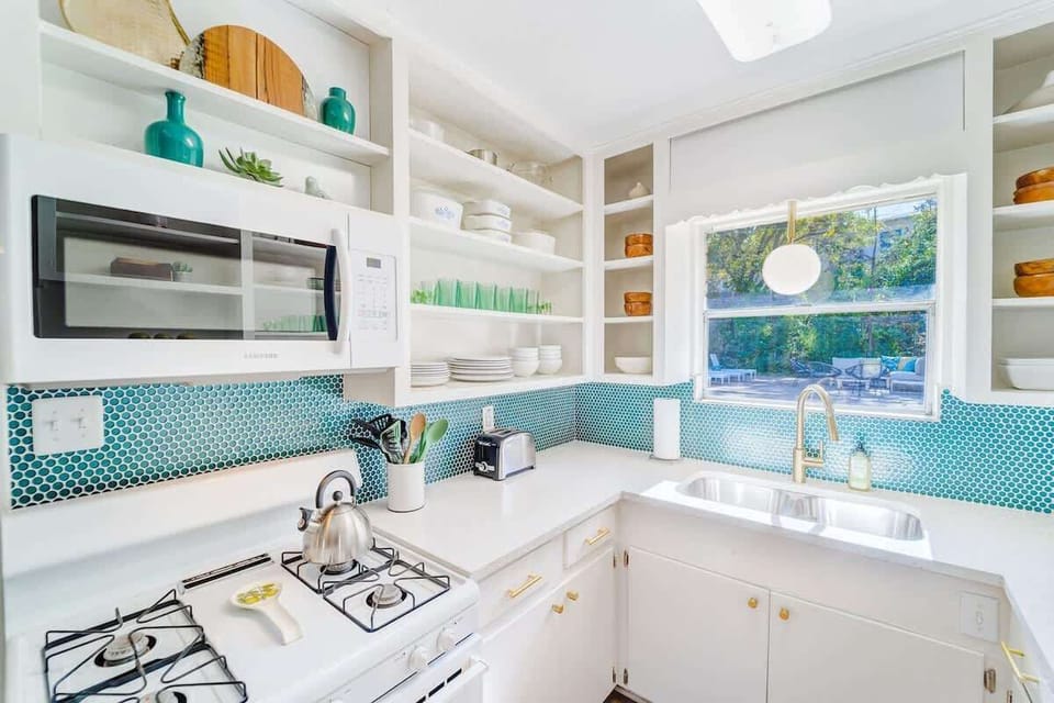 The kitchen is stocked with dishes and appliances to make meals at home.