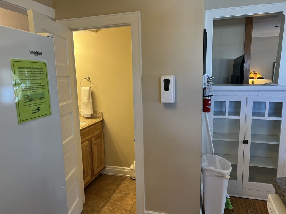 Door to hall half bathroom near kitchen