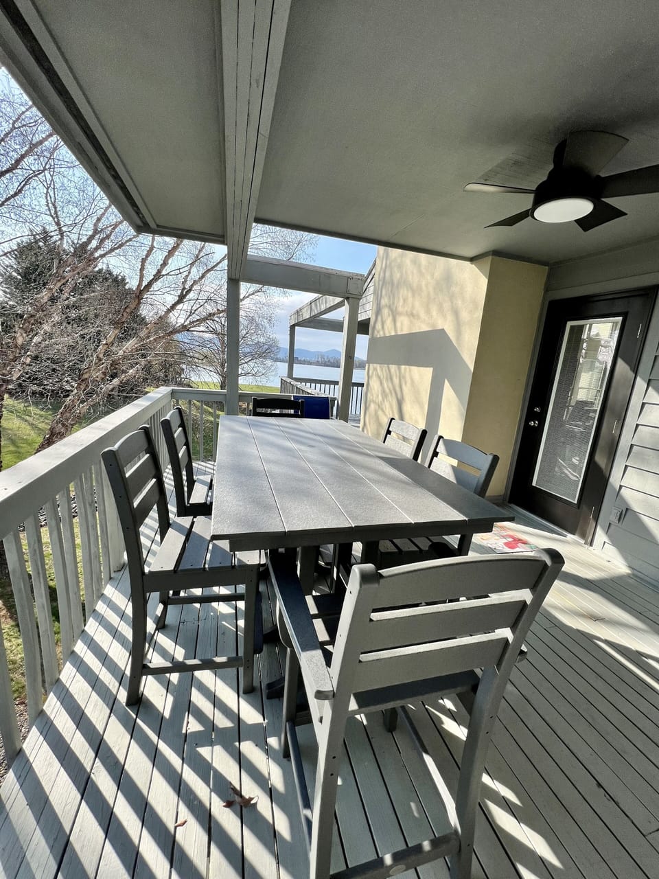 Counter height polywood table and 6 chairs on side covered deck  