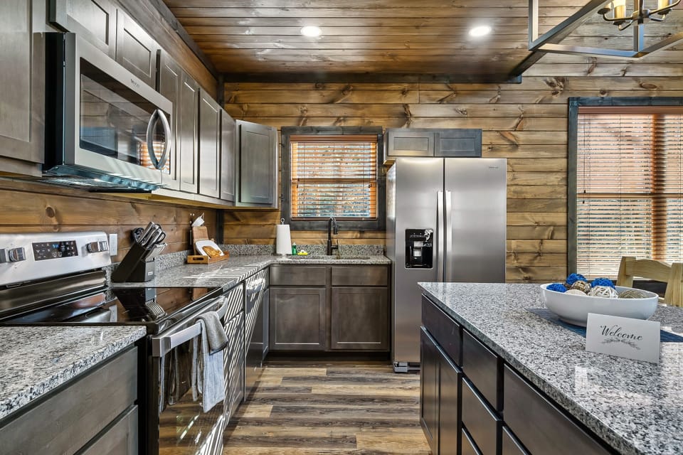 Fully-supplied kitchen with stainless steel appliances and granite countertops. 