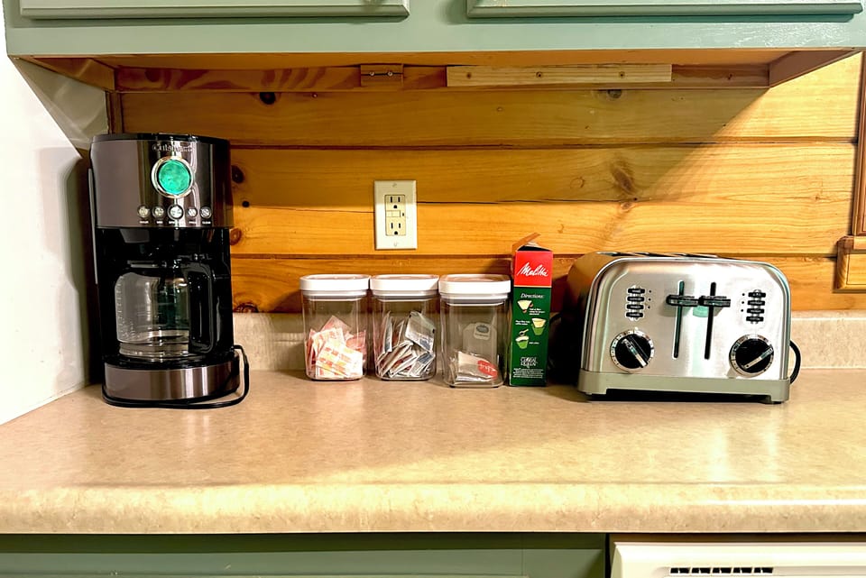 Coffee maker with Folgers coffee, cream, sugar. Teas and electric kettle