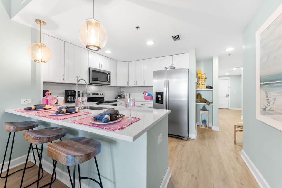 Your gourmet kitchen features gleaming stainless steel appliances, elegant pendant lighting, and a spacious island perfect for morning coffee or evening wine.