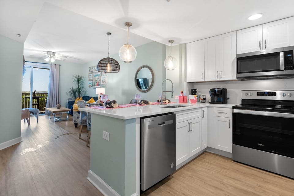 Your fully equipped kitchen features modern appliances and an island perfect for preparing meals and morning coffee together.
