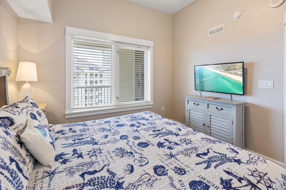 Drift off to peaceful sleep in your cozy coastal-themed bedroom with nautical bedding and entertainment at your fingertips.
