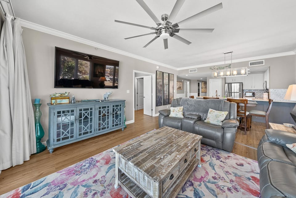Relax in your spacious living room with comfortable leather seating, entertainment center, and open kitchen perfect for memorable moments.